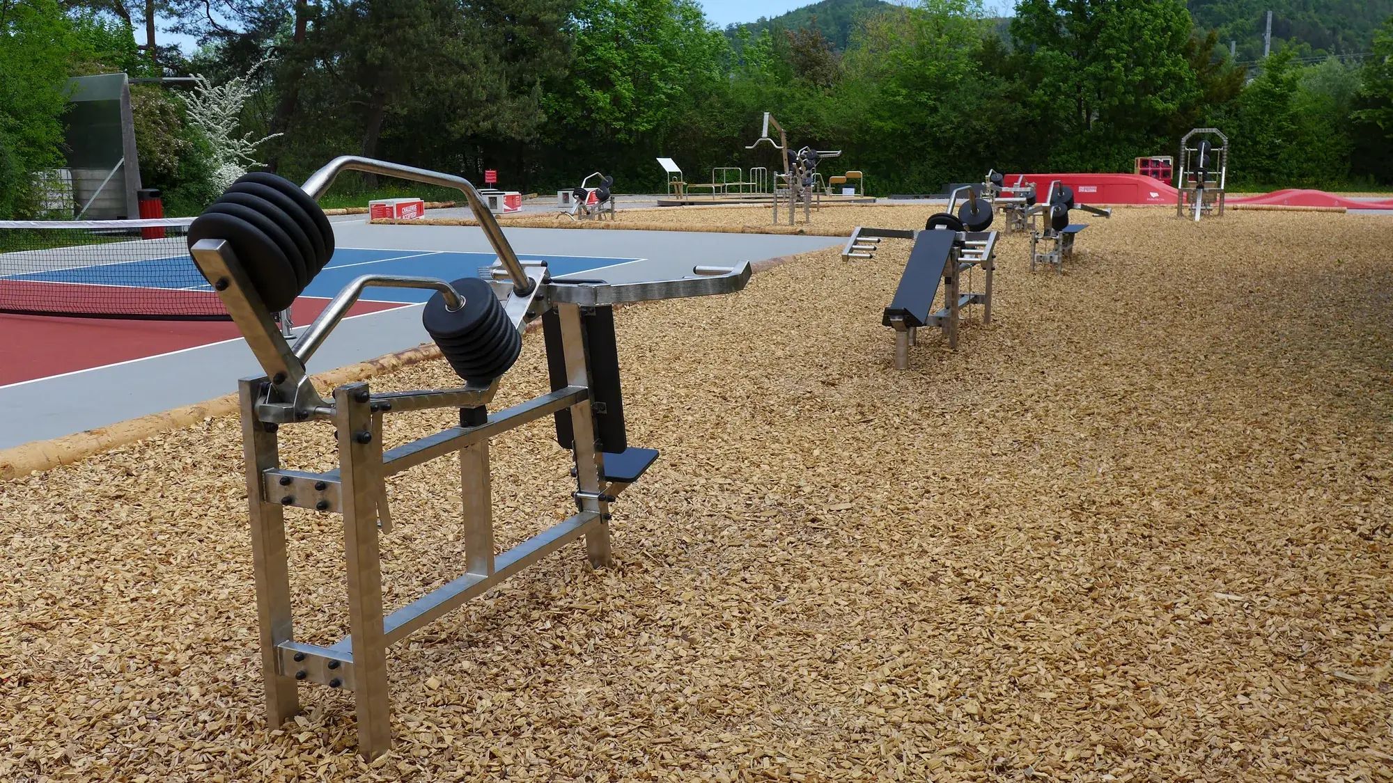 Kraftgerät aus Edelstahl auf Holzschnitzeln im Bewegungspark Goldbrunnenweg in Liestal